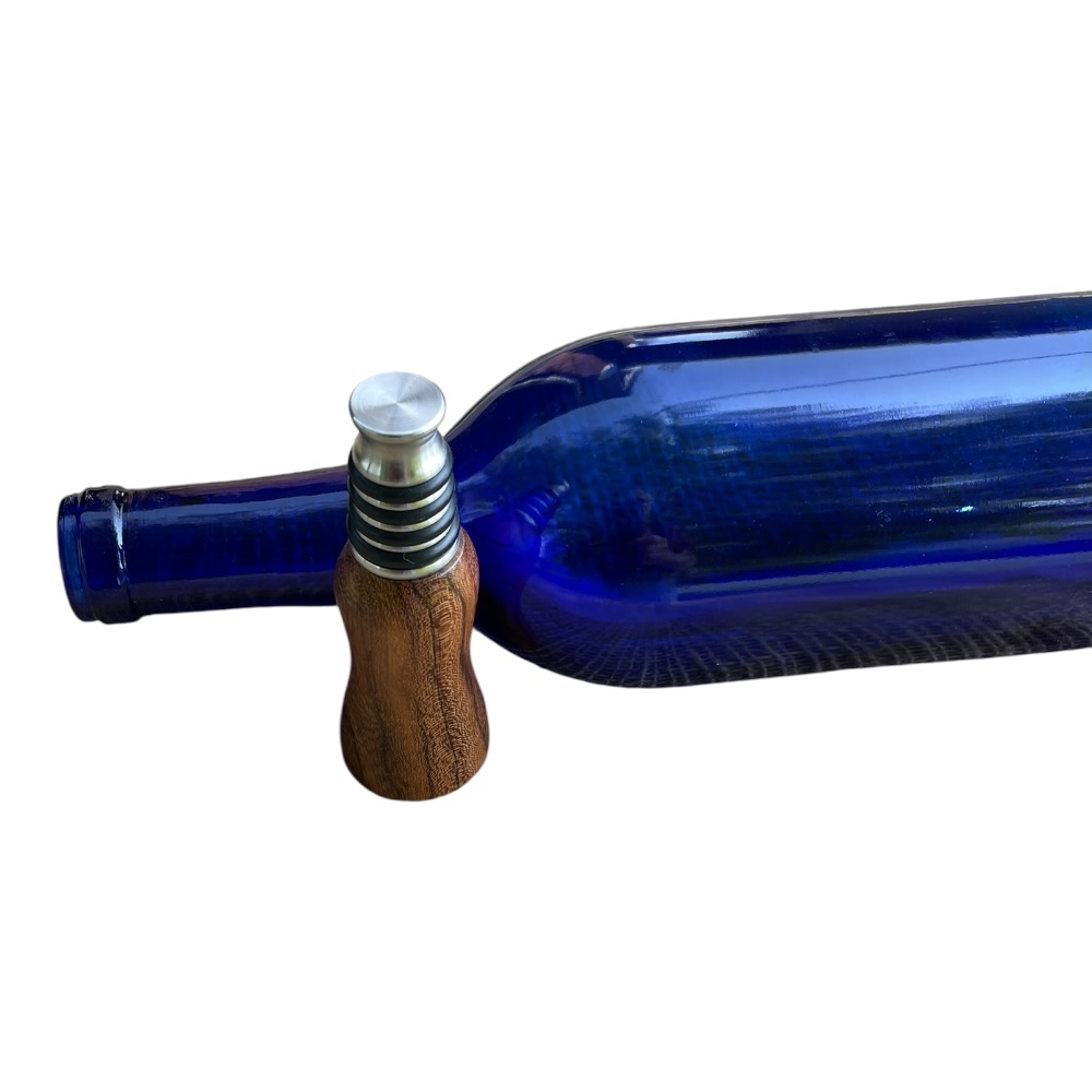 Handmade stainless steel bottle stopper with a turned red oak wood handle displaying natural grain and smooth finish.